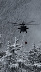 Sgt. 1st Class Ethan Major, a flight medic with the New Hampshire Army National Guard, and stricken hiker Patrick Bittman are hoisted into a Black Hawk helicopter Dec. 19, 2024, during a successful search and rescue on Franconia Ridge.