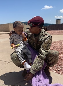 Sgt. 1st Class Kaishaun Waller holding his son photo