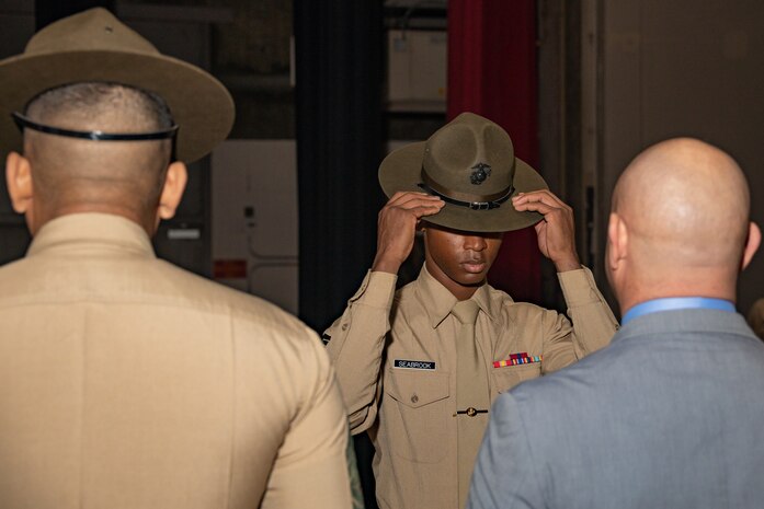 New U.S. Marine Corps Drill Instructor, Sgt. Reginald Seabrook with DI school, dons his campaign cover for the first time during the Marine Corps Recruit Depot San Diego DI School 1-25 graduation ceremony at MCRD San Diego, California, Dec. 18, 2024. During DI school, Marines developed leadership skills, mastered drill, met physical fitness requirements and learned how to make Marines. Our Marines continue to serve their nation and their Corps through their lived examples of our values and by helping to identify and select potential recruits who may have what it takes to earn the title. (U.S. Marine Corps photo by Lance Cpl. Janell B. Alvarez)