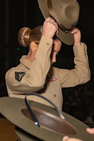 New U.S. Marine Corps Drill Instructor, Staff Sgt. Chantel Reyesvillarreal with DI school, dons her campaign cover for the first time during the Marine Corps Recruit Depot San Diego DI School 1-25 graduation ceremony at MCRD San Diego, California, Dec. 18, 2024. During DI school, Marines developed leadership skills, mastered drill, met physical fitness requirements and learned how to make Marines. Our Marines continue to serve their nation and their Corps through their lived examples of our values and by helping to identify and select potential recruits who may have what it takes to earn the title. (U.S. Marine Corps photo by Lance Cpl. Janell B. Alvarez)