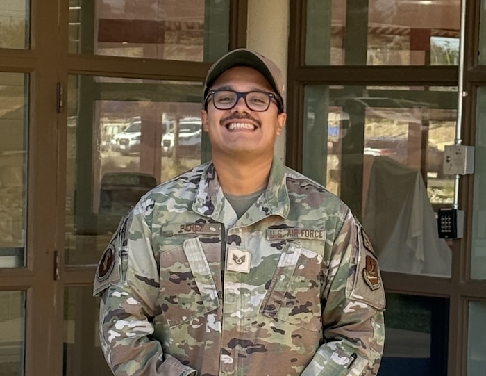 Airman stands in front of the entrance to the brig.
