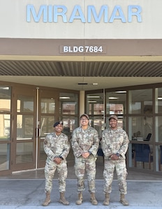 photo of three Airmen outside of the entrance to the Miramar Brig.