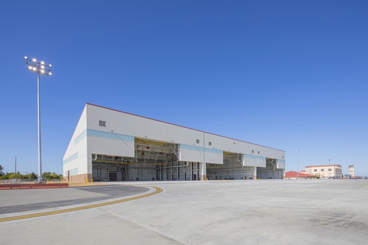 two story white building with hangar doors open