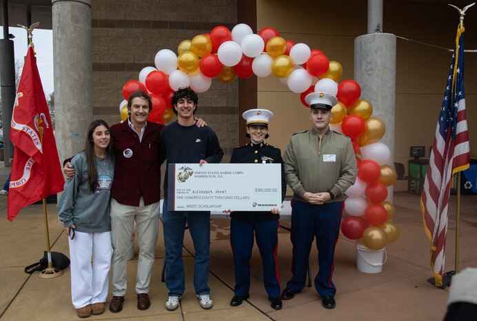 Alexander Grant, center, recipient of the Naval Reserve Officers Training Corps scholarship, poses for a photograph with his family and U.S. Marines in Folsom, California, Dec. 17, 2024. Grant was awarded a $180,000 scholarship into the NROTC program.  The intent of the NROTC Scholarship Program is to educate and train highly qualified young men and women for careers as commissioned officers in the Marine Corps and Naval service. (U.S. Marine Corps photo by Staff Sgt. Ryan Harvey)