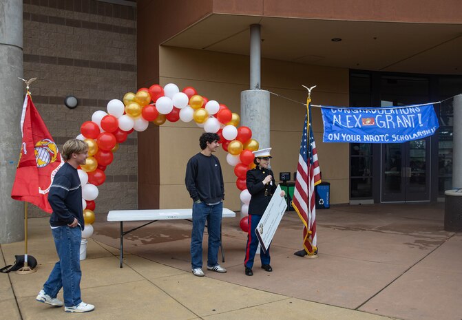 U.S. Marine Corps Capt. Isabel Billinge, executive officer of Recruiting Station Sacramento, presents Alexander Grant, recipient of the Naval Reserve Officers Training Corps scholarship, with a ceremonial check during a scholarship presentation in Folsom, California, Dec. 17, 2024. Grant was awarded a $180,000 scholarship into the NROTC program.  The intent of the NROTC Scholarship Program is to educate and train highly qualified young men and women for careers as commissioned officers in the Marine Corps and Naval service. (U.S. Marine Corps photo by Staff Sgt. Ryan Harvey)