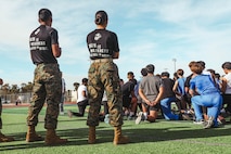 U.S. Marine Corps Pvt. Miguel Lopez, left, and Pfc. Alexsa RojasRomero, both recruiter assistants with Recruiting Sub-Station Hemet, Recruiting Station San Diego, overlook students during a weight room takeover at Beaumont High School in Beaumont, California, Dec. 16, 2024. A weight room takeover is an event where Marines engage with students in a gym setting, leading workouts and demonstrating fitness techniques as part of a community outreach or recruitment effort. (U.S. Marine Corps photo by Cpl. Alejandro Fernandez)