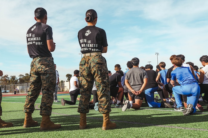 U.S. Marine Corps Pvt. Miguel Lopez, left, and Pfc. Alexsa RojasRomero, both recruiter assistants with Recruiting Sub-Station Hemet, Recruiting Station San Diego, overlook students during a weight room takeover at Beaumont High School in Beaumont, California, Dec. 16, 2024. A weight room takeover is an event where Marines engage with students in a gym setting, leading workouts and demonstrating fitness techniques as part of a community outreach or recruitment effort. (U.S. Marine Corps photo by Cpl. Alejandro Fernandez)
