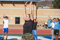 U.S. Marine Corps Staff Sgt. Elaina Dinson, station commander with Recruiting Sub-Station Hemet, Recruiting Station San Diego, trains students during a weight room takeover at Beaumont High School in Beaumont, California, Dec. 16, 2024. A weight room takeover is an event where Marines engage with students in a gym setting, leading workouts and demonstrating fitness techniques as part of a community outreach or recruitment effort. (U.S. Marine Corps photo by Cpl. Alejandro Fernandez)