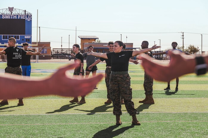 U.S. Marine Corps Staff Sgt. Elaina Dinson, station commander with Recruiting Sub-Station Hemet, Recruiting Station San Diego, trains students during a weight room takeover at Beaumont High School in Beaumont, California, Dec. 16, 2024. A weight room takeover is an event where Marines engage with students in a gym setting, leading workouts and demonstrating fitness techniques as part of a community outreach or recruitment effort. (U.S. Marine Corps photo by Cpl. Alejandro Fernandez)