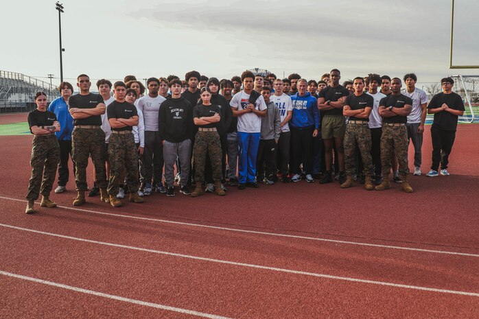 U.S. Marines with Recruiting Sub-Station Hemet, Recruiting Station San Diego, and members of the Beaumont High School football team, pose for a photograph during a weight room takeover at Beaumont High School in Beaumont, California, Dec. 16, 2024. A weight room takeover is an event where Marines engage with students in a gym setting, leading workouts and demonstrating fitness techniques as part of a community outreach or recruitment effort. (U.S. Marine Corps photo by Cpl. Alejandro Fernandez)