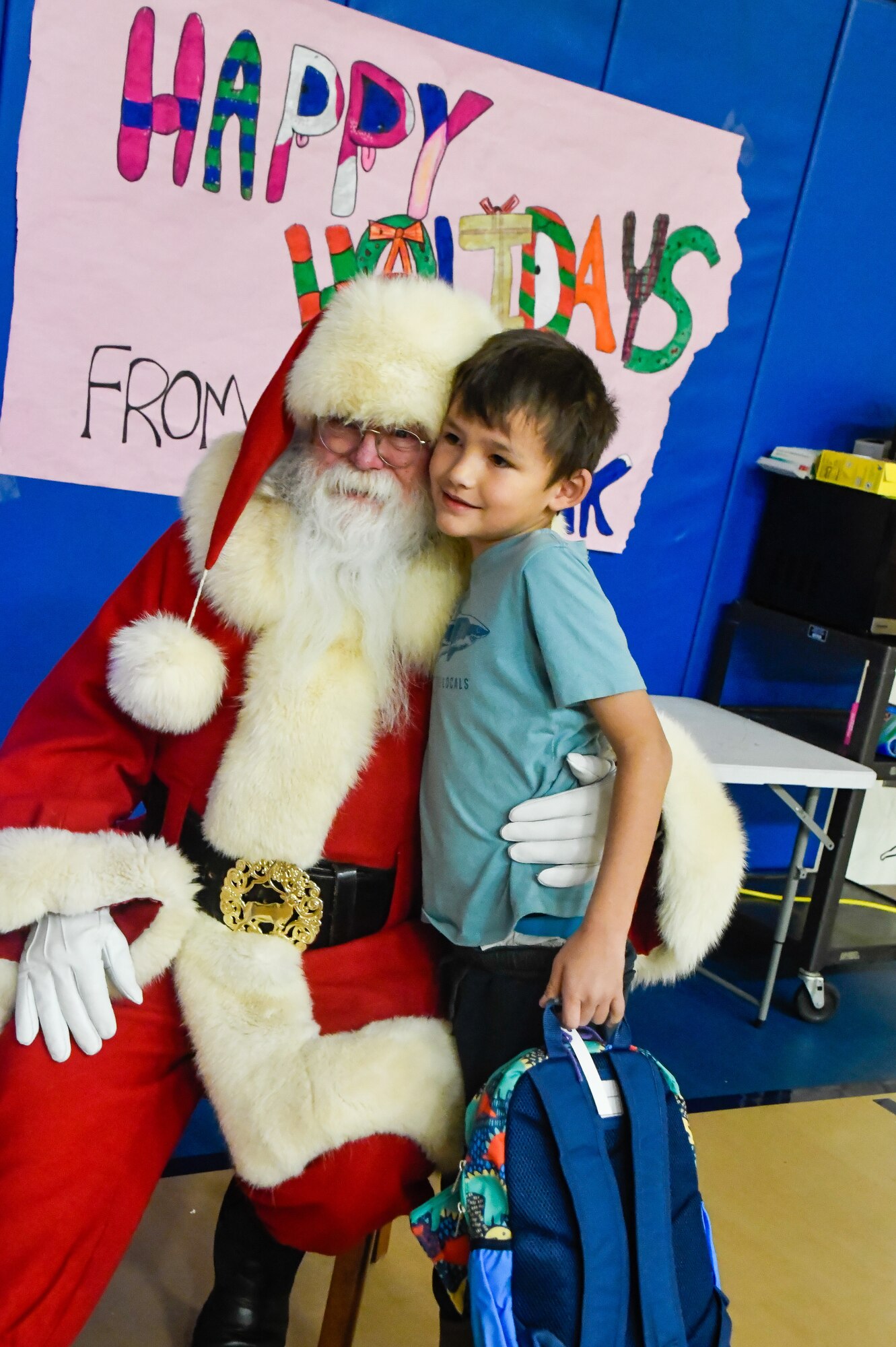 Santa Claus hugs a child.