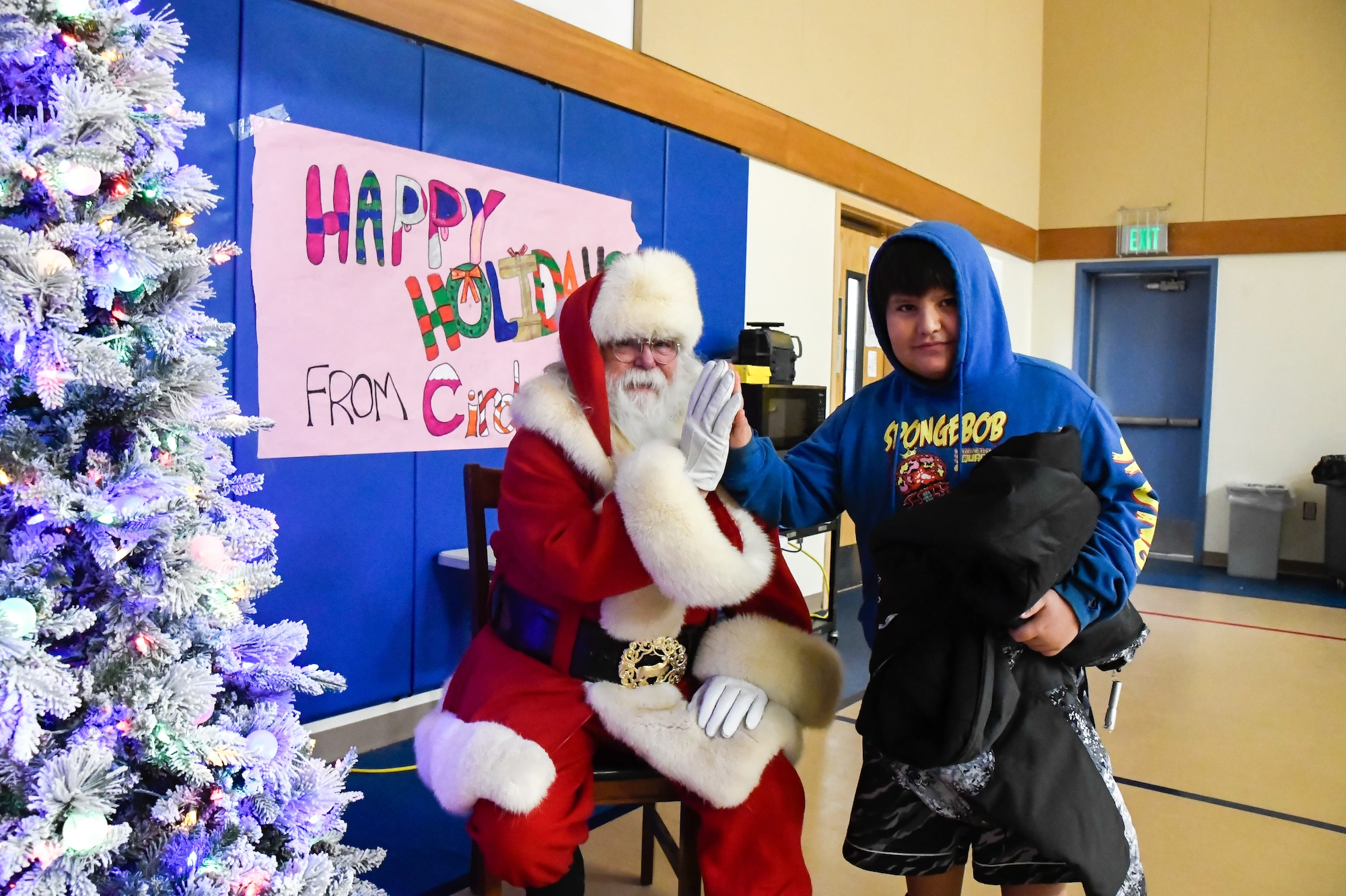 Santa Claus gives a high five to a child while visiting Circle, Alaska.