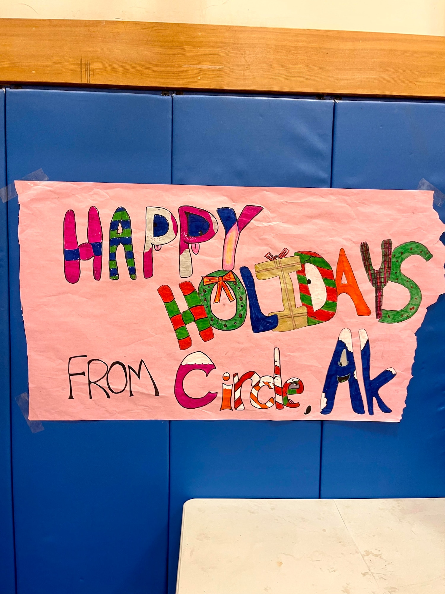 A sign made by the children  that reads Happy Holiday from Circle, Alaska