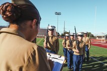 U.S. Marine Corps Sgt. Alanah SunigaJimenez, a canvassing recruiter with Recruiting Sub-Station National City, Recruiting Station San Diego, evaluates cadets during a Junior Reserve Officer Training Corps drill competition at Sweetwater High School in National City, California, Dec. 7, 2024. The Junior Reserve Officer Training Corps drill competition is a formal event where cadets perform synchronized marching routines and precision drill to demonstrate discipline, teamwork and leadership skills. (U.S. Marine Corps photo by Cpl. Alejandro Fernandez)