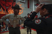 U.S. Marine Corps Sgt. Matthew Dailey, a drill instructor with Bravo Company, 1st Recruit Training Battalion, Marine Corps Recruit Depot San Diego, inspects a cadet's uniform during a Junior Reserve Officer Training Corps drill competition at Sweetwater High School in National City, California, Dec. 7, 2024. The Junior Reserve Officer Training Corps drill competition is a formal event where cadets perform synchronized marching routines and precision drill to demonstrate discipline, teamwork and leadership skills. (U.S. Marine Corps photo by Cpl. Alejandro Fernandez)
