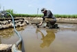 Master Sgt. Dustin Turner, right, an explosive ordnance disposal technician assigned to the Kentucky Air National Guard’s 123rd Civil Engineer Squadron, examines soil for osseous material in a rice paddy in Quang Binh Province, Vietnam, in June 2023. Turner was part of a U.S.-led team that recovered the remains of two U.S. Marine pilots who were lost in combat over Vietnam in December 1972. (Courtesy photo)