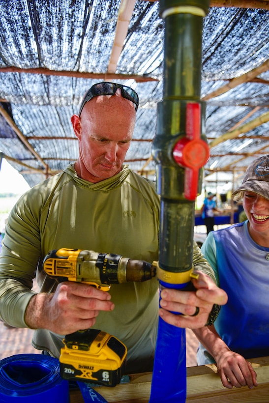 Master Sgt. Dustin Turner, an explosive ordnance disposal technician assigned to the Kentucky Air National Guard’s 123rd Civil Engineer Squadron, secures a pipe as part of a sifting system to screen wet top soil for osseous material in Quang Binh Province, Vietnam, in June 2023.