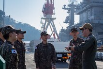 Cmdr. Steve Miller, right, assistant chief of staff for plans and engagements for Commander, Task Force 70, speaks to representatives of the Republic of Korea Navy’s Maritime Task Flotilla (MTF) 7 on the pier beside the Nimitz-class aircraft carrier USS George Washington (CVN 73) during the forces’ Composite Warfare Committee Meeting (CWCM), Dec. 4.