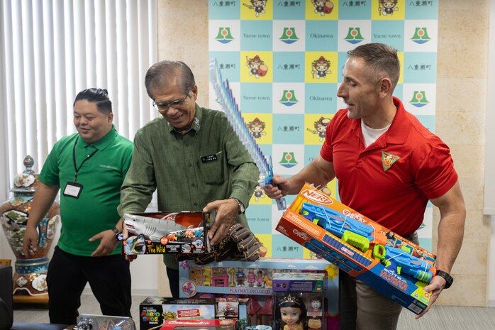 Yasuhiro Arakaki, left, the mayor of Yaese Town and U.S. Marine Corps Col. William Pacatte, commanding officer of Marine Corps Air Station Futenma, look at toy donations during the Merry Marine Toy Drive in Yaese Town, Okinawa, Japan, Dec. 12, 2024.