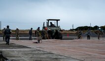 U.S. Air Force and Japan Air Self-Defense Force members move a piece of folding fiberglass matting during an airfield damage repair training exercise at Hyakuri Air Base, Japan, Nov. 21, 2024.