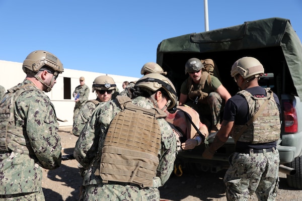 Hospital Corpsman 3rd Class (HM3) Ryan Baker helps the Expeditionary Resuscitative Surgical System (ERSS) team into unloading a simulated patient off a truck to transition to Role 2 care during a training evolution conducted by Naval Expeditionary Medicine Warfighter Development Center (NEMWDC)on Bravo 1 Range, Camp Pendleton, Dec. 16. The ERSS team is comprised of a seven-man team with Expeditionary Medicine Facility Kilo Camp Lejeune training in preparation for an upcoming deployment in Spring 2025.