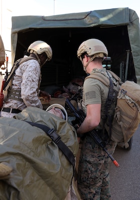 Hospital Corpsman 2nd Class (HM2) Kwame Obengyeboah and Hospital Corpsman 3rd Class (HM3) Charlie Spencer loads a high-fidelity simulated manikin into a truck during a training evolution as part of an Integrated Expeditionary Resuscitative Surgical System (ERSS) and En-route Care System (ERCS)course conducted by Naval Expeditionary Medicine Warfighter Development Center (NEMWDC) at Bravo 1 Range, Camp Pendleton, Calif., Dec. 16. Obengyeboah and Spencer medically evacuated the simulated patient from point-of-injury to the ERSS team for Role 2 care. Spencer is currently stationed at Recon Training Command (RTC) on Camp Pendleton where he provides support for students going through BRC. Obengyeboah is an instructor at NEMWDC and plays the role of Medical Quick Reaction Force (MEDQRF) during the ERSS course guiding the BRC students in Role 1 care.