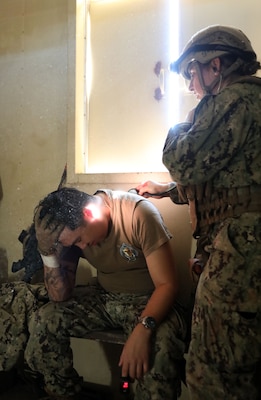 Lt. Kaitlin Walter listens to any abnormalities in the lower lung lobes of Information Technician First Class (IT1) Vincent Wu who was involved in a simulated motor vehicle accident during a training evolution on Bravo 1 Range conducted by Naval Expeditionary Medicine Warfighter Development Center (NEMWDC) on Dec. 16.  Walter is an Emergency Room Physician Assistant for Navy Medicine Readiness and Training Command (NMRTC) Camp Lejeune, N.C., set to deploy with her Expeditionary Resuscitative Surgical System (ERSS) team in Spring 2025. Wu is an instructor at NEMWDC fulfilling the role of an actor for the ERSS course.