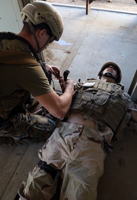 Hospital Corpsman 3rd Class (HM3) Charlie Spencer applies a tourniquet on a high-fidelity simulated manikin during a training evolution as part of the Integrated Expeditionary Resuscitative Surgical System (ERSS) and En-route Care System (ERCS) course conducted by Naval Expeditionary Medicine Warfighter Development Center (NEMWDC) at Bravo 1 Range, Camp Pendleton, Calif., Dec. 16. Spencer graduated from the Basic Reconnaissance Course (BRC) and is now attending the Special Operation Independent Duty Corpsman training. Spencer is currently stationed at Recon Training Command (RTC) on Camp Pendleton where he provides support for students going through BRC. Spencer expressed “I like seeing all the roles coming into play together from the point-of-injury to ERSS and then to the next echelon of care after that. Seeing it all put together is an eye-opener and gives you an idea of what is happening with the patient after you hand them off.”