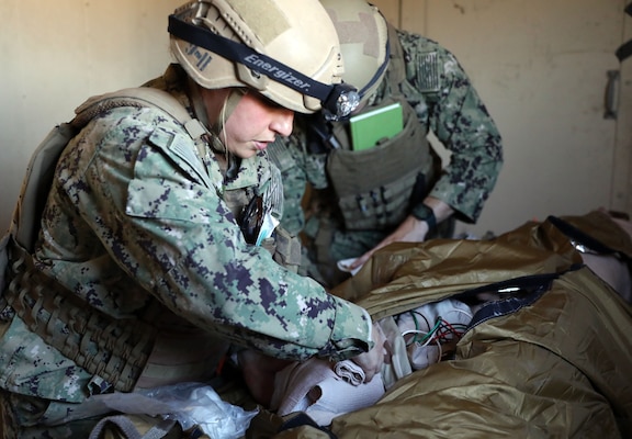 Lt. Kaitlin Walter wraps an amputated leg on a high-fidelity manikin caused by a simulated improvised explosive device (IED) blast during a training evolution conducted by Naval Expeditionary Medicine Warfighter Development Center (NEMWDC) at Bravo 1 Range, Camp Pendleton, Dec. 16.  Walter is an emergency room physician assistant with Navy Medicine Readiness and Training Command (NMRTC) Camp Lejeune, N.C., who is set to deploy with the ERSS team in Spring 2025. Walter mentions “Flexibility is key because our team is so small. You have to hold multiple roles which puts us out of our comfort zone, so learning how to be flexible is the biggest thing I learned.”