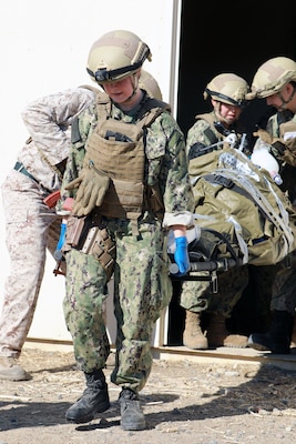 Lt. Cmdr. Mary Ayres, general surgeon for Expeditionary Resuscitative Surgical System Team 11 based at Camp Lejeune, N.C., helps carry a simulated patient for transport to higher echelon care during a training evolution as part of the Integrated Expeditionary Resuscitative Surgical System (ERSS) and En-route Care System (ERCS) course conducted by Naval Expeditionary Medicine Warfighter Development Center (NEMWDC) at Bravo 1 Range, Camp Pendleton, Calif., Dec. 16. The ERSS, a seven-member mobile medical team providing surgical care for critically injured patients supporting military operations, and the ERCS, which ensures medical assessment, treatment, and care during patient transport to higher-capacity medical assets, were put to the test in hyper-realistic scenarios. (Navy photo by Arsenio R. Cortez Jr.)