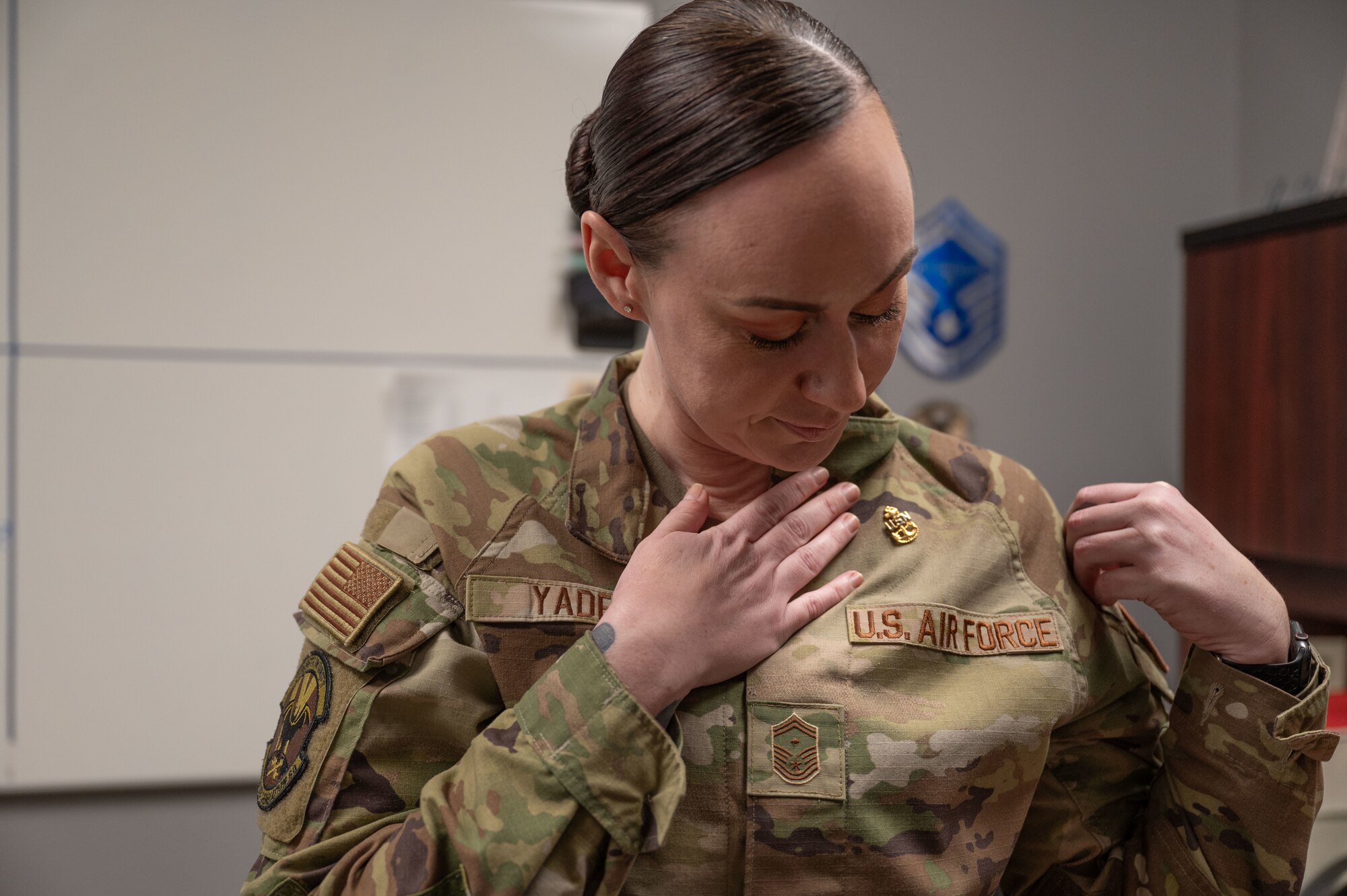 U.S. Air Force Senior Master Sgt Destini Yaden, 9th Bomber Generation Squadron first sergeant, looks down at her anchors she received after completing the Navy Senior Enlisted Academy at Dyess Air Force Base, Texas, Dec 11, 2024. The program focuses on national military strategies, enhancing troop care, problem-solving and using storytelling to connect leadership skills. (U.S. Air Force photo by Airman 1st Class Emma Anderson)