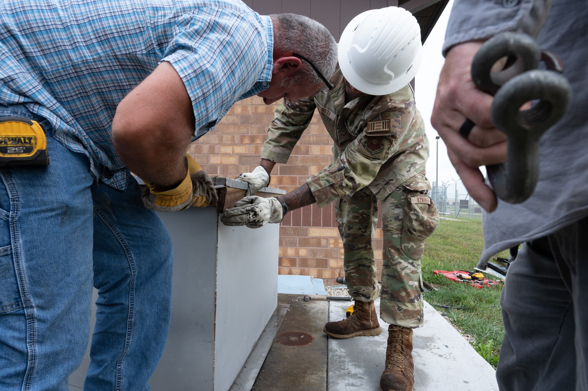 U.S. Air Force Airmen and civilian contractors prepare the base of an air conditioning unit for removal at Whiteman Air Force Base, Mo., Sept. 24, 2024. The replacement of the air conditioning unit allowed for Military Working Dogs to remain in proper conditions within the kennels. (U.S. Air Force photo by Senior Airman Joseph Garcia)