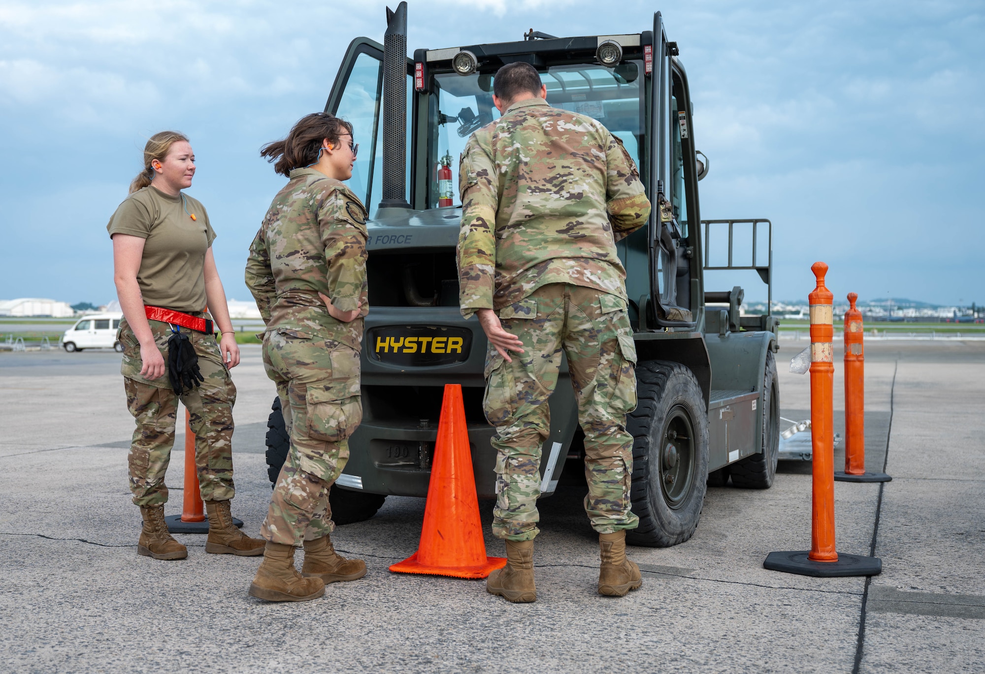 Service members inspect forklift.