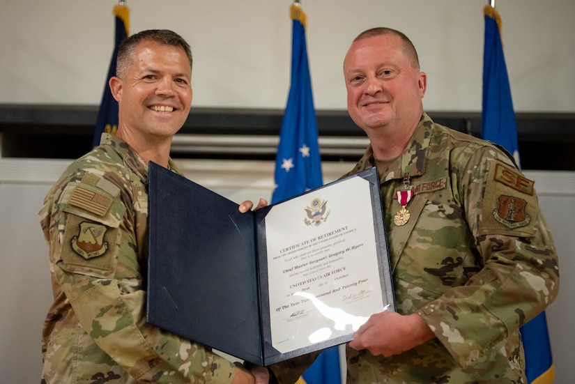 Chief Master Sgt. Gregory Myers, right, 123rd Security Forces Squadron manager, receives his certificate of retirement from Lt. Col. Jason Ray, former 123rd SFS operations officer, during a ceremony at the Kentucky Air National Guard Base in Louisville, Ky., Oct. 13, 2024.