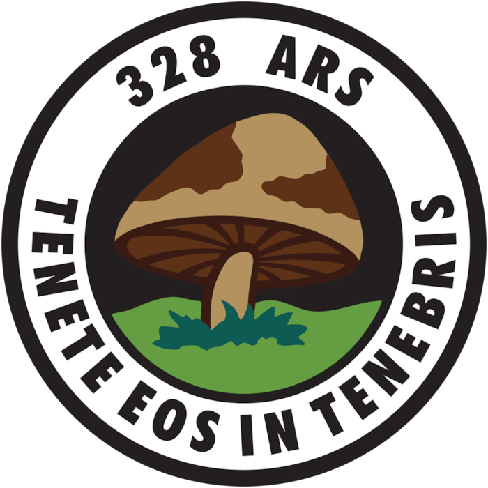 A mushroom in the grass. Reads, "328 ARS | TENETE EOS IN TENEBRIS."