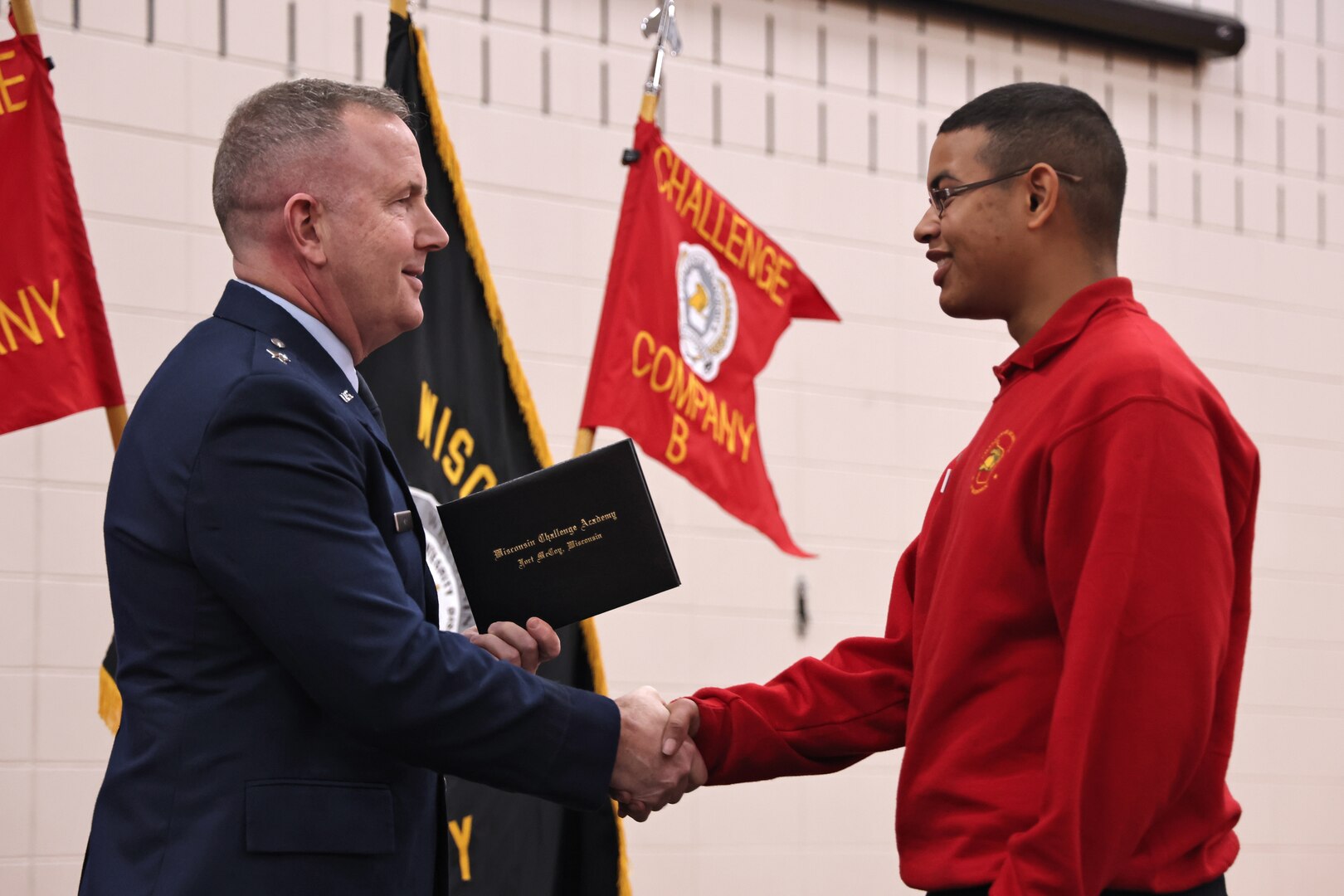 U.S. Air Force Brig. Gen. David May, interim adjutant general for the Wisconsin National Guard, presents graduation certificates to 86 cadets of the Wisconsin National Guard Challenge Academy's class 53, December 21, 2024, at Necedah High School in Necedah, Wisconsin.