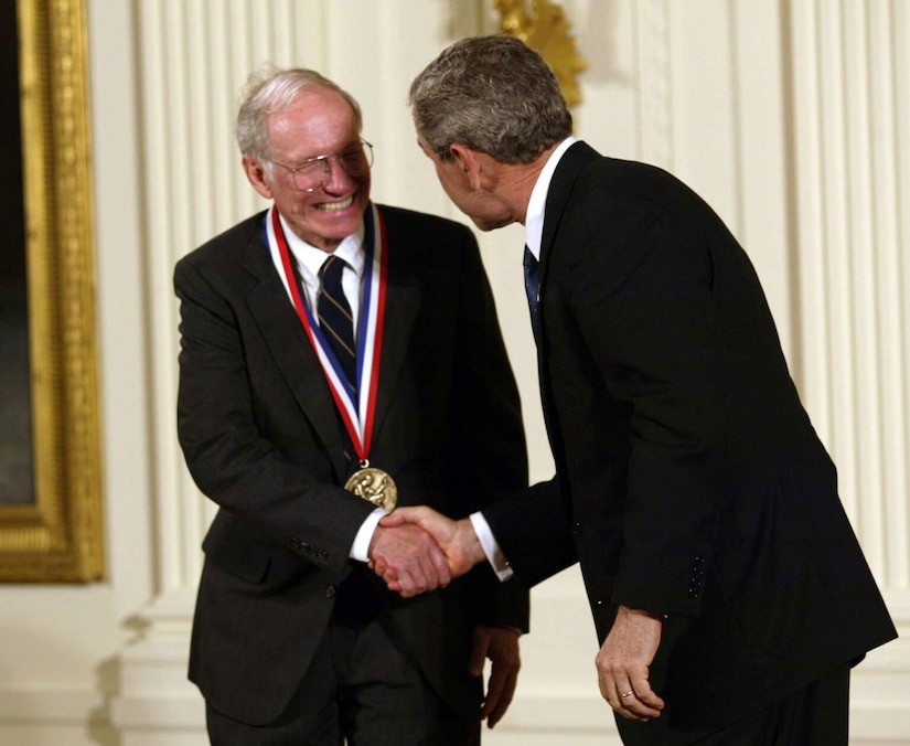 Two men shake hands.