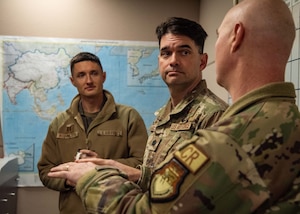 Man Speaks to two other men.