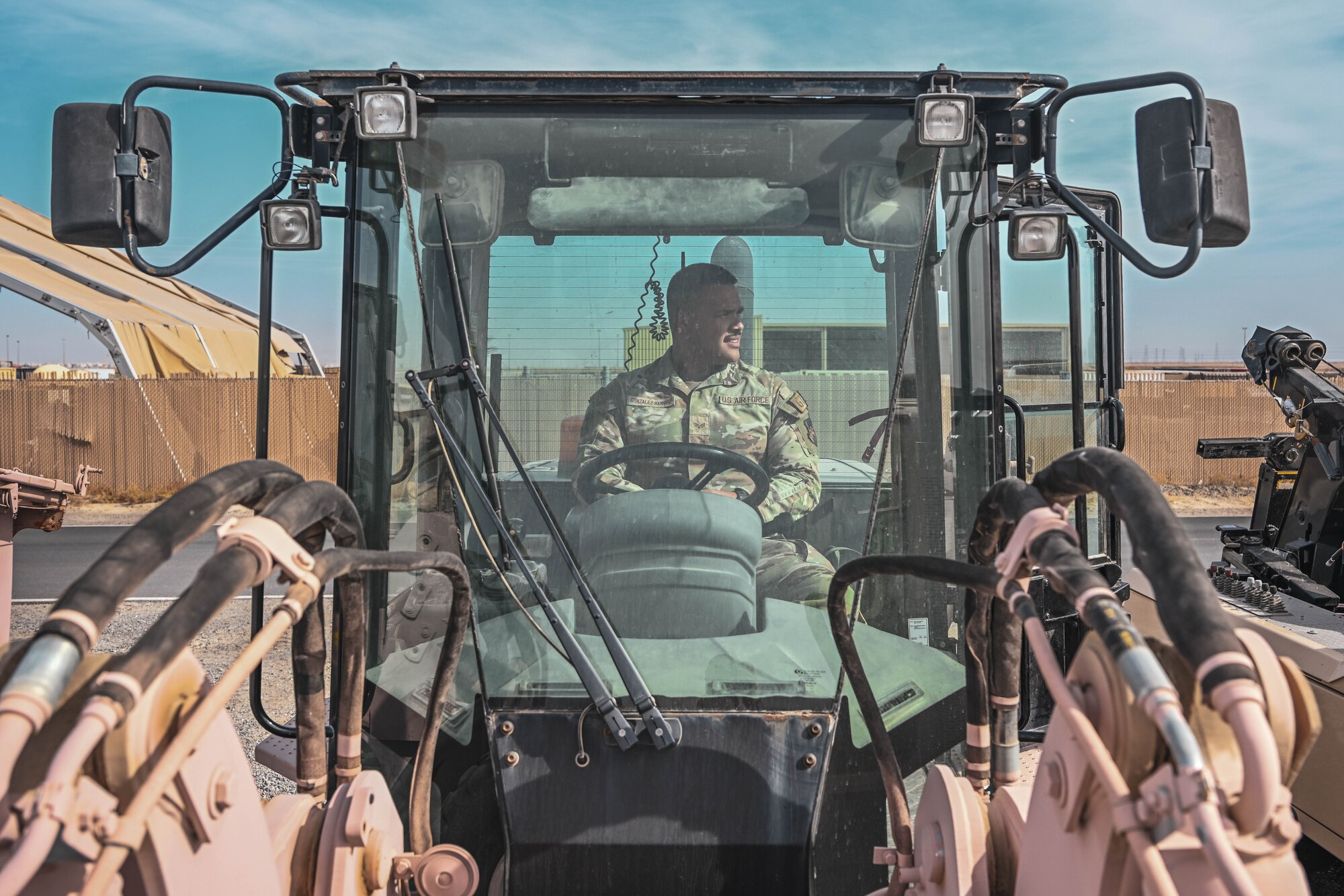 A man in uniform sits in a forklift.