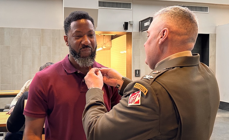 Col. Calvin A. Kroeger, commander of Army Corps of Engineers' Fort Worth District, pins a lapel pin on Charles Baker, a recruit who was hired on the spot at the Army-sponsored Career Fair, April 13, 2024, at Globe Life Stadium, Arlington, Texas. (US Army photo by Richard Bumgardner, SWF Public Affairs)