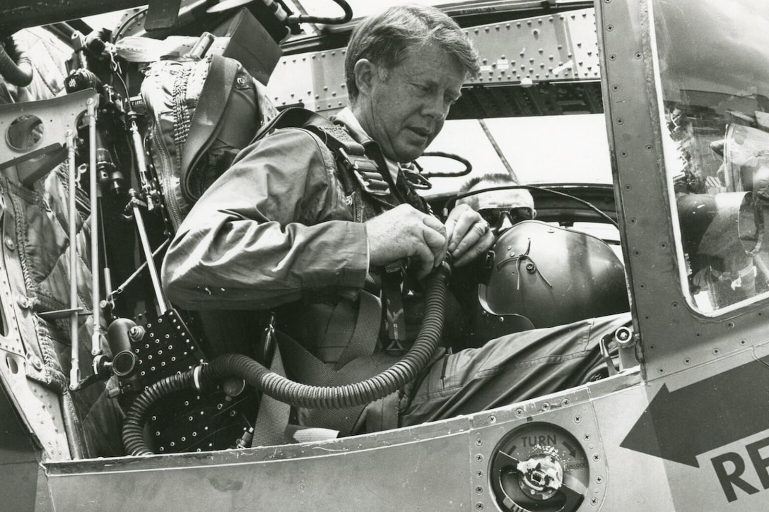 A man suits up in an aircraft.