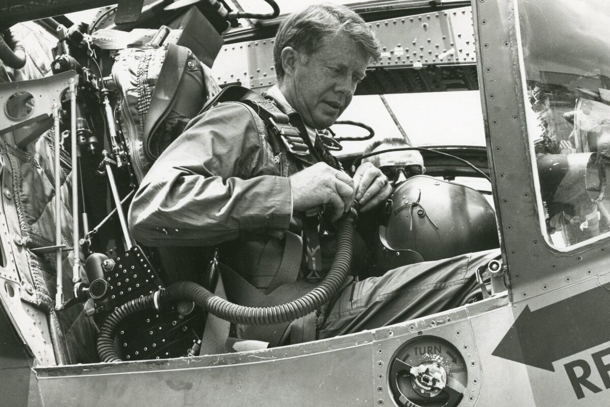 A man suits up in an aircraft.