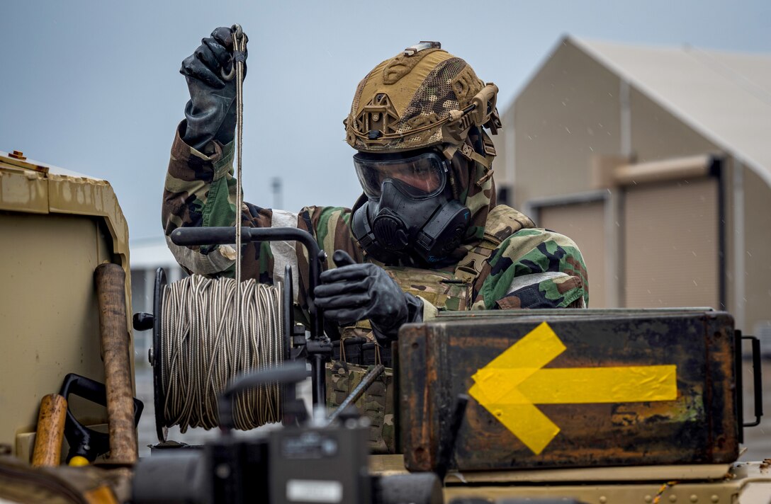 USAF Airman pulls a rope in preparation for disarming a simulated explosive during exercise Crown Royal 24-2
