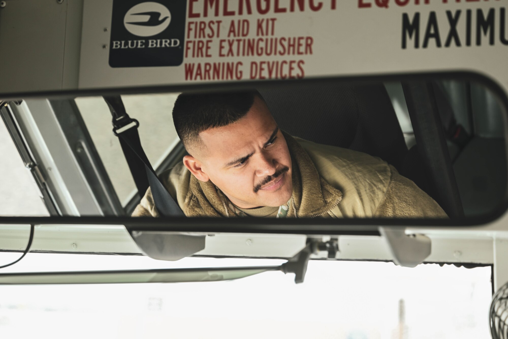 A man in uniform drives a bus.