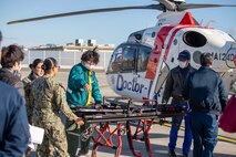 U.S. Sailors from the Marine Corps Air Station Iwakuni Branch Health Clinic and Hiroshima Prefectural Hospital’s Dr. Helicopter staff prepare to unload and transporting equipment during a simulated neonatal medevac at MCAS Iwakuni, Japan, Dec. 19, 2024. MCAS Iwakuni and the Hiroshima Prefectural Hospital Neonatal ICU conducted a simulated neonatal medevac to establish a process to safely transfer critically ill neonates born at Branch Health Clinic Iwakuni to a higher echelon of care. (U.S. Marine Corps photo by Sgt. Randall Whiteman)