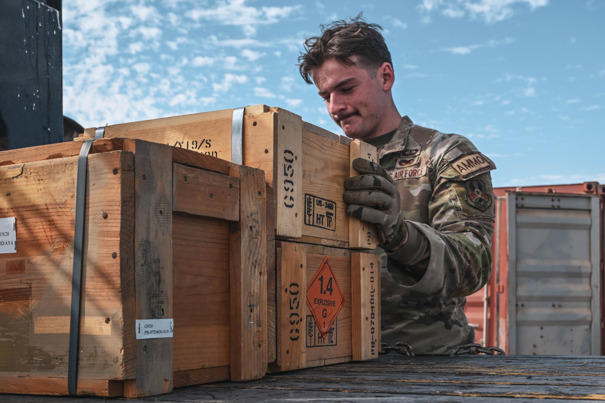 A man in uniform places a box on top of another box.