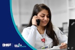 Nurse wearing white scrubs answers phone.