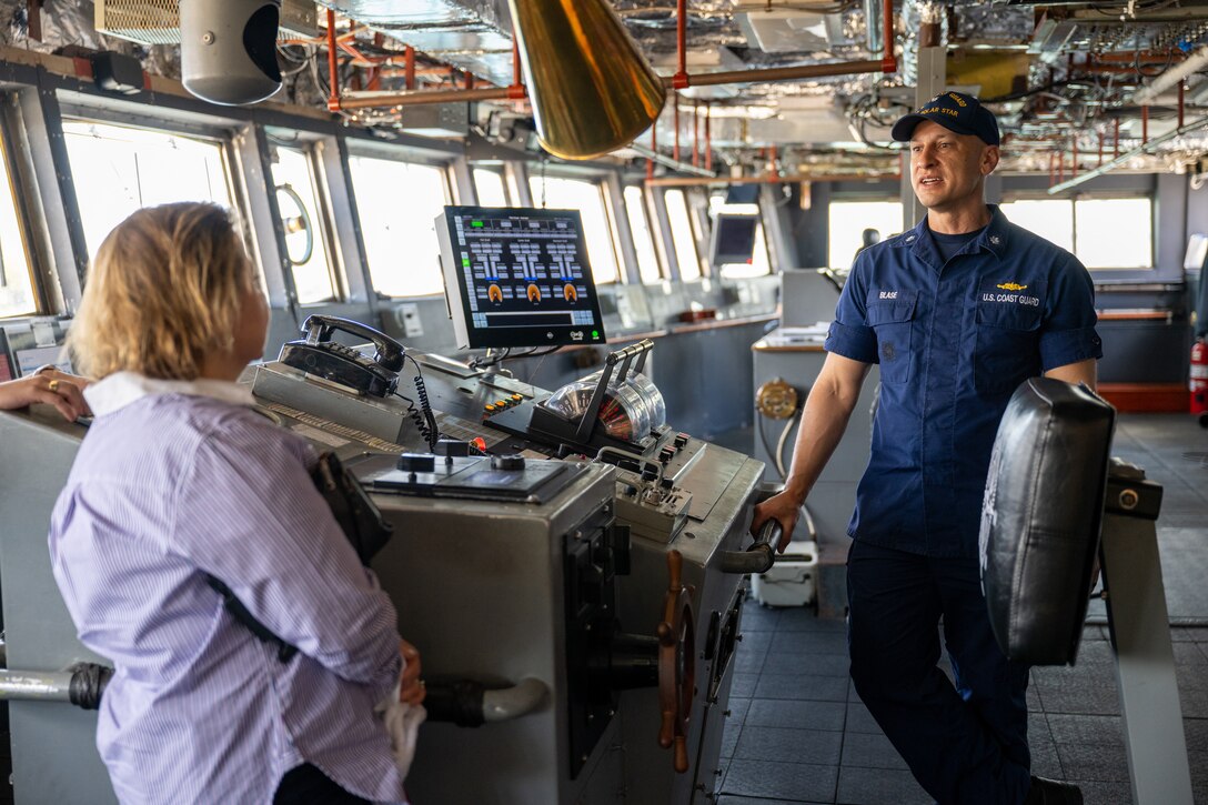 U.S. Coast Guard Cmdr. Samuel Blase, executive officer, U.S. Coast Guard Cutter Polar Star (WAGB 10), speaks with Consul General Christine Elder on the bridge of the Polar Star at Royal Australian Naval Base HMAS Kuttabul in Sydney, Dec. 23, 2024. The Polar Star stopped in Sydney on its way to Antartica in support of Operation Deep Freeze, a joint service, inter-agency support operation for the National Science Foundation, which manages the United States Antarctic Program.  (U.S. Coast Guard photo by Petty Officer 2nd Class Briana Carter)