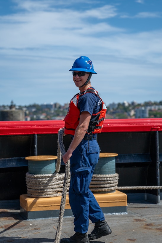 Seaman Andrew Ream, a crewmember aboard U.S. Coast Guard Cutter Polar Star (WAGB 10), stands ready at his mooring station while the Polar Star prepares to depart Royal Australian Naval Base HMAS Kuttabul in Sydney, Dec. 27, 2024. The Polar Star stopped in Sydney on its way to Antartica in support of Operation Deep Freeze, a joint service, inter-agency support operation for the National Science Foundation, which manages the United States Antarctic Program.  (U.S. Coast Guard photo by Petty Officer 2nd Class Briana Carter)