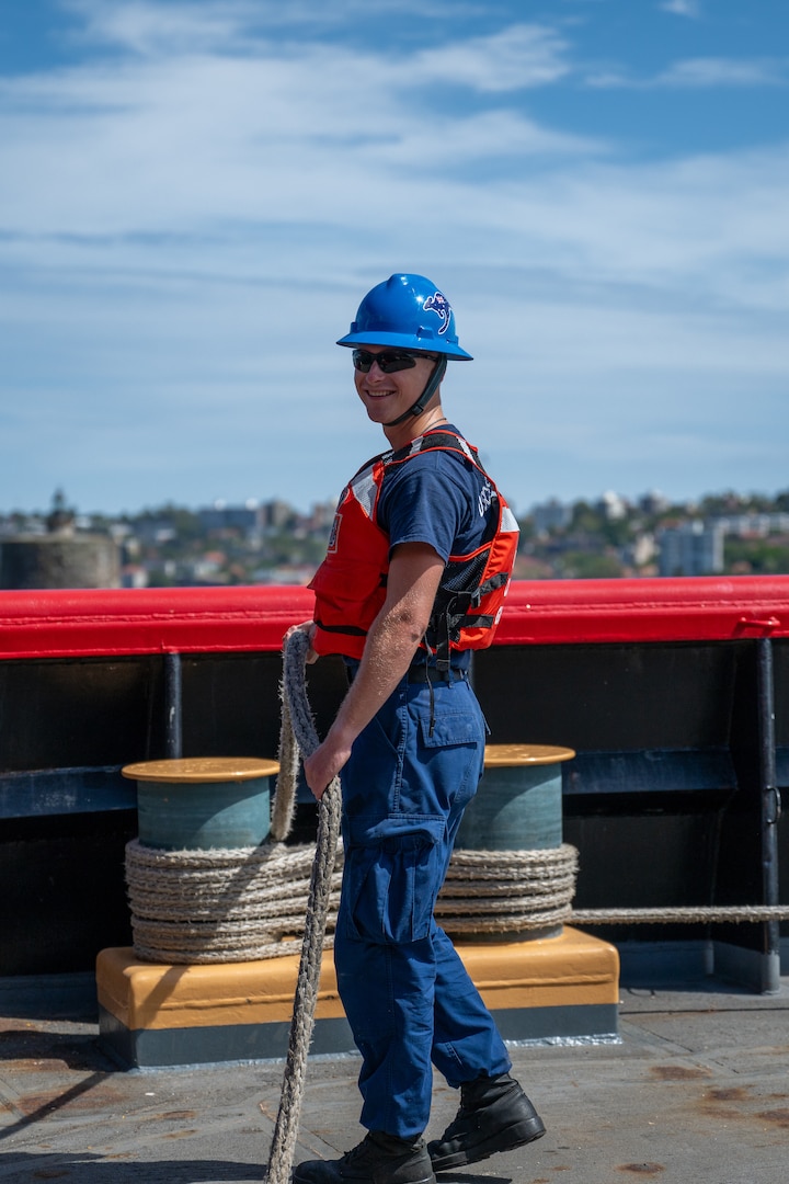 Seaman Andrew Ream, a crewmember aboard U.S. Coast Guard Cutter Polar Star (WAGB 10), stands ready at his mooring station while the Polar Star prepares to depart Royal Australian Naval Base HMAS Kuttabul in Sydney, Dec. 27, 2024. The Polar Star stopped in Sydney on its way to Antartica in support of Operation Deep Freeze, a joint service, inter-agency support operation for the National Science Foundation, which manages the United States Antarctic Program.  (U.S. Coast Guard photo by Petty Officer 2nd Class Briana Carter)